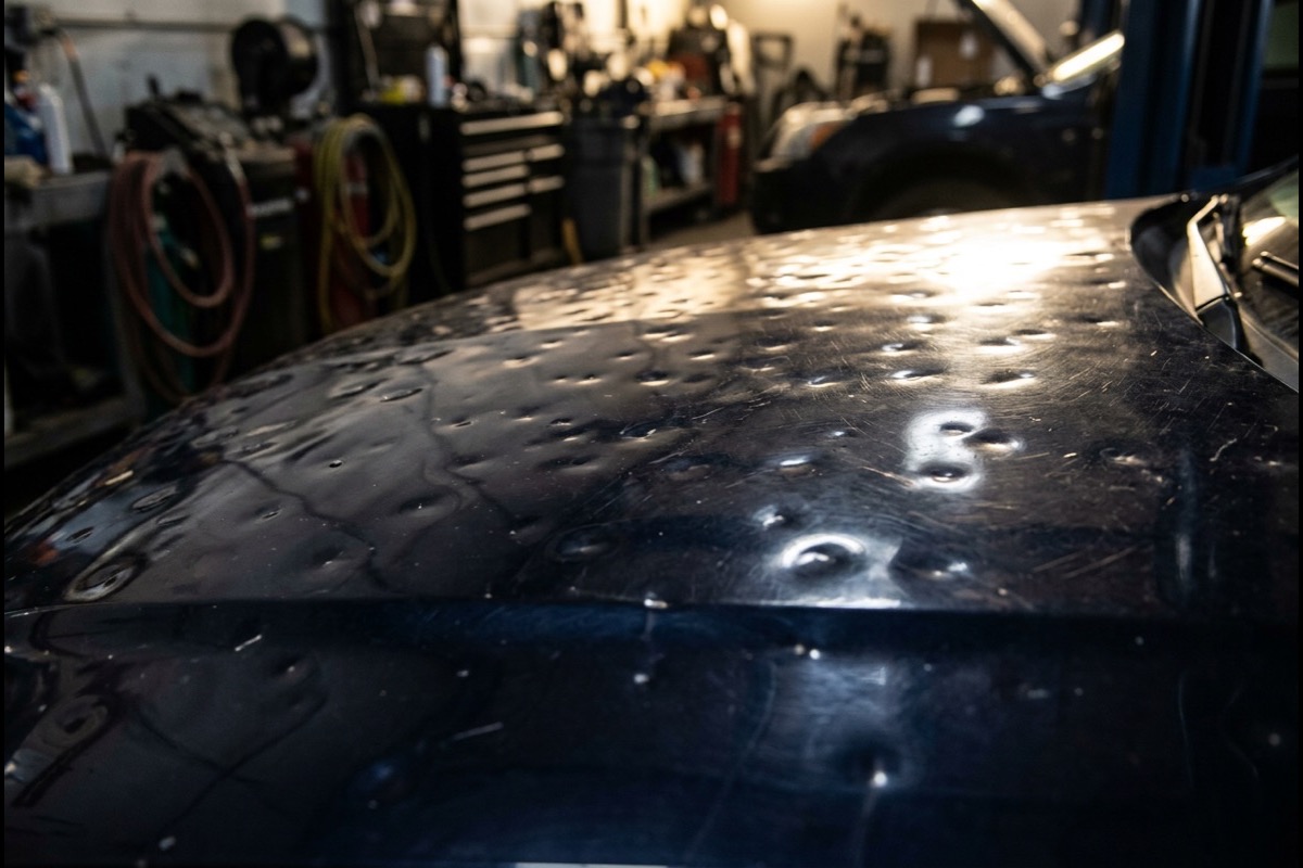 Hail dent pattern on a navy hood