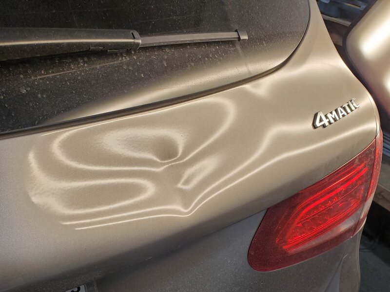 Large dent in a Mercedes trunk lid before PDR